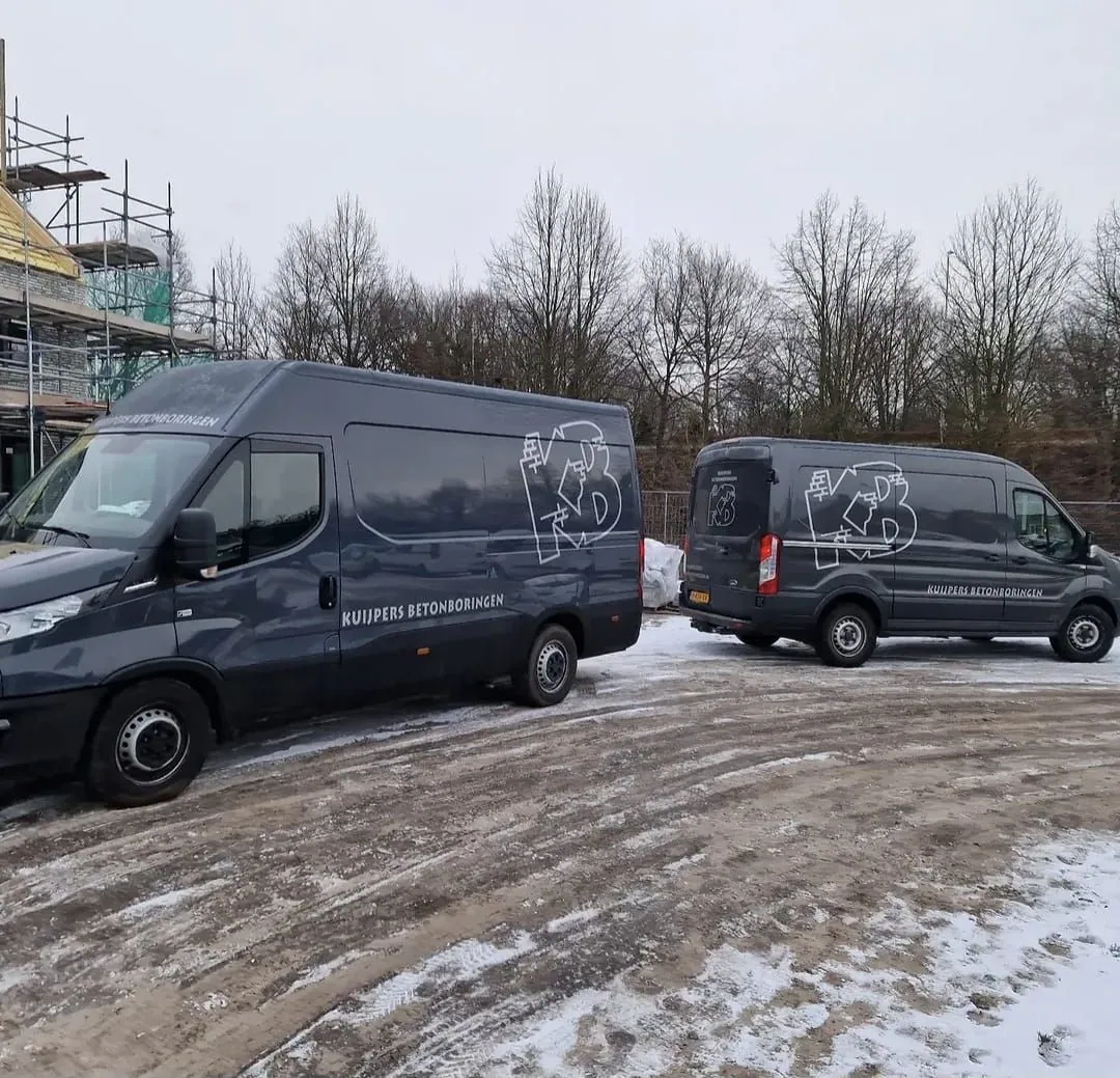 Twee bedrijfswagens van Kuijpers Betonboringen op locatie